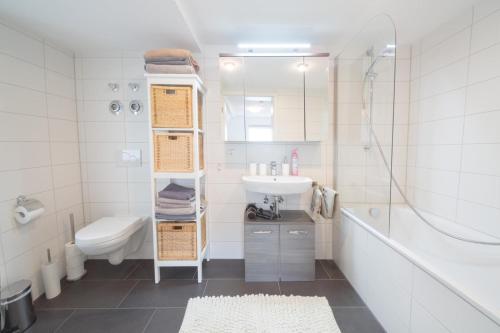 a white bathroom with a sink and a toilet at Superhost Flat near Opera in Bayreuth