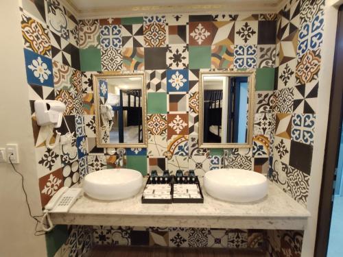 baño con 2 lavabos y pared de azulejos en Bonjour Sa Pa Hotel, en Sa Pa