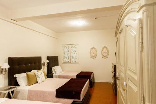 a hotel room with two beds and a closet at Ester Guest House in Chaves