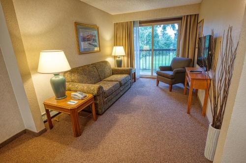 a living room with a couch and a table with a lamp at Sophie Station Suites in Fairbanks