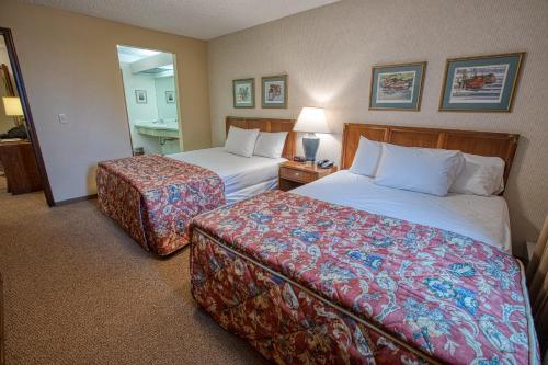 a hotel room with two beds and a table with a lamp at Sophie Station Suites in Fairbanks