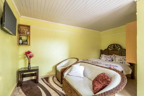 1 dormitorio con cama, sofá y TV en AnD Suites, en Nairobi