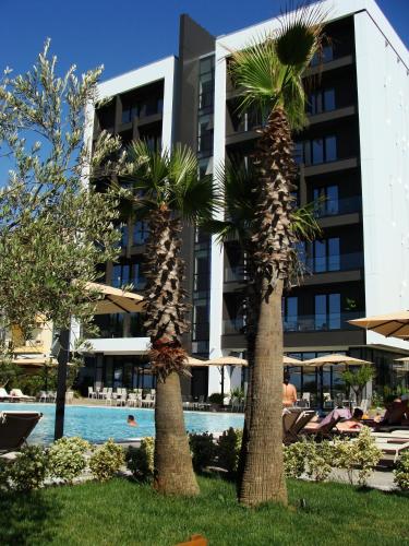 two palm trees in front of a building at Supreme Hotel in Golem