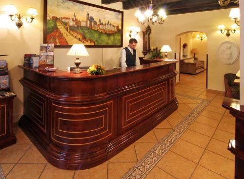 
a man standing in front of a counter in a restaurant at Boutique Hotel Constans in Prague
