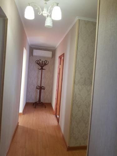an empty hallway with a chandelier and a room with a wooden floor at Apartment on Lakoba 60 in Novy Afon