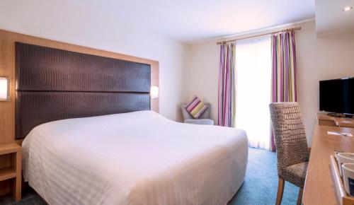 a hotel room with a bed and a desk and a television at The Big Blue Hotel - Blackpool Pleasure Beach in Blackpool