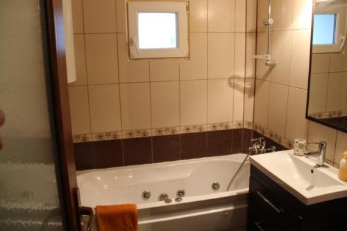 a bathroom with a bath tub and a sink at Faleza Nord Sea View Apartment in Constanţa
