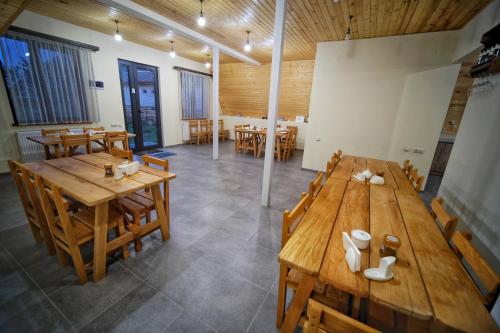 a large room with wooden tables and chairs at Hotel TWINS Achkhoti in Stepantsminda