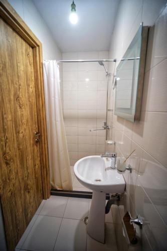a bathroom with a sink and a shower at Hotel TWINS Achkhoti in Stepantsminda