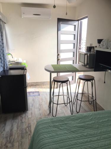 a kitchen with two stools and a table in a room at Mi Depa Gardenia en pleno Centro de la Ciudad in Ciudad Valles