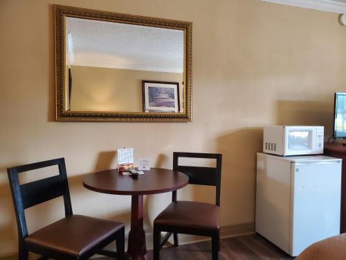 a room with a small table and chairs and a microwave at Colonial House Motel in Pigeon Forge