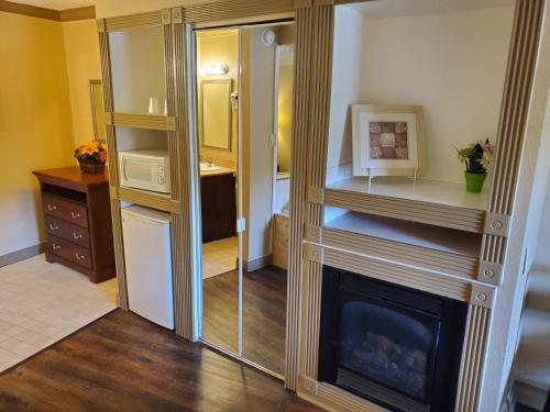 a living room with a fireplace and a mirror at Colonial House Motel in Pigeon Forge