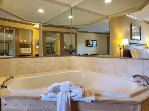 a bathroom with a tub with towels on it at Colonial House Motel in Pigeon Forge