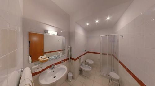 y baño con 2 aseos, lavamanos y ducha. en Hotel Panoramic, en San Vito lo Capo