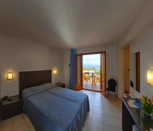 1 dormitorio con 1 cama y balcón con mesa en Hotel Panoramic, en San Vito lo Capo