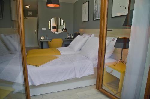 a bedroom with a white bed and a mirror at B&B ALIBI in Bardejov