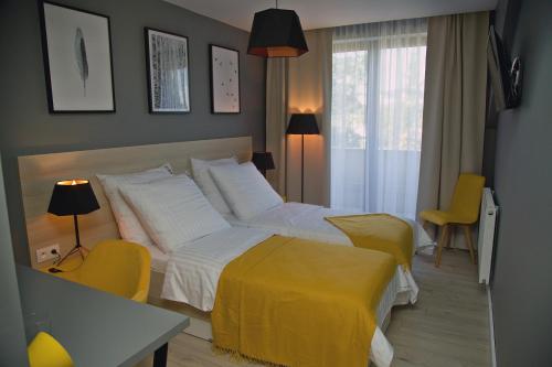 a bedroom with two beds and a yellow blanket at B&B ALIBI in Bardejov