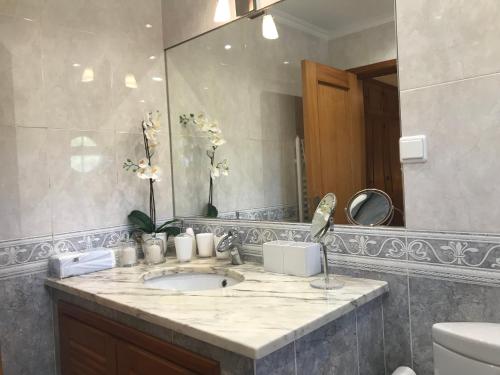 a bathroom with a sink and a large mirror at Quinta da Chapeleira em Azeitão in Azeitao