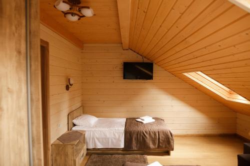 a bedroom with a bed in a wooden room at GUTSULWOOD in Yablunytsya