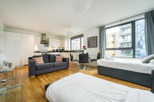 a bedroom with a bed and a living room at Greenwich Two Bedroom Apartments in London