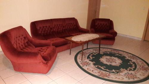 a living room with two couches and a table at PENZION EUROPA Diakovce in Diakovce