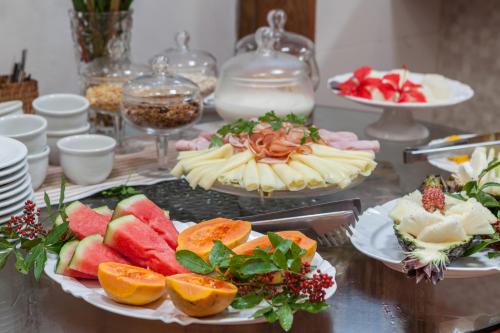 a table topped with plates of food with fruit at Pousada Cajueiro Trancoso in Trancoso
