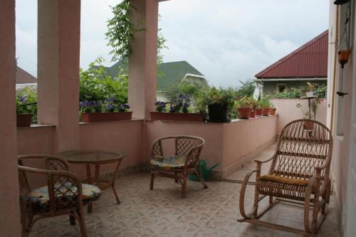 a balcony with chairs and tables and potted plants at Vilni Kimnaty in Mukacheve