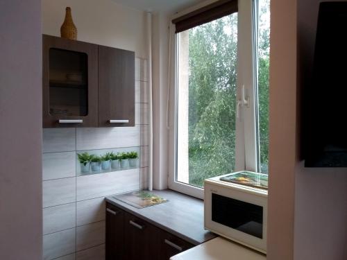 a kitchen with a window and a table with a television at Mieszkanie 2 pokoje ul. Skrzetuskiego LSM Lublin in Lublin