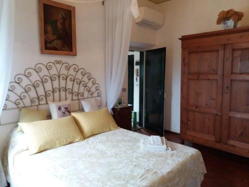 a bedroom with a white bed and a wooden cabinet at Il Melarancio Country House in Scandicci