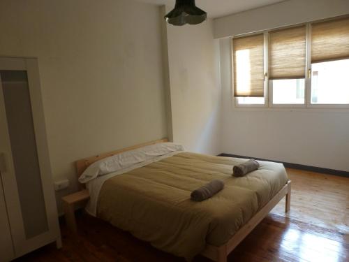 a bedroom with a bed with two brown pillows on it at Hostal del Arquitecto in Vitoria-Gasteiz
