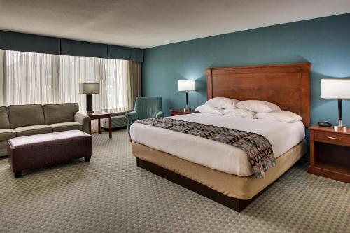 a hotel room with a large bed and a chair at Sonesta Essential Houston Hobby Airport in Houston