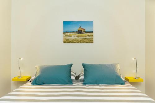 een slaapkamer met een bed met blauwe kussens bij Hideout Suites - from Eagle Beach in Palm-Eagle Beach