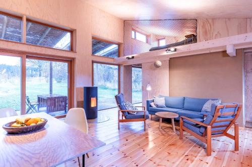 een woonkamer met een blauwe bank en een tafel bij Studio Zempow, ökologisches Ferienhaus in Zempow