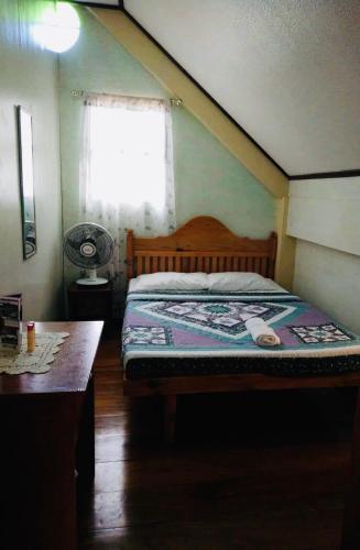 a bedroom with a bed and a window and a table at Mayoyao View Inn in Banaue