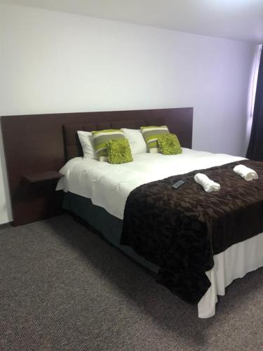 a bedroom with a large bed with green pillows at Vila Orizont Straja in Straja