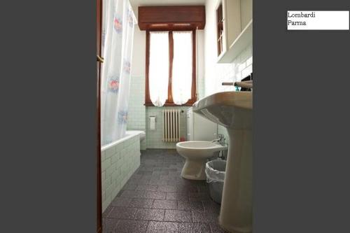 uma casa de banho com um WC, um lavatório e uma banheira em Lombardi Ramazzini em Parma