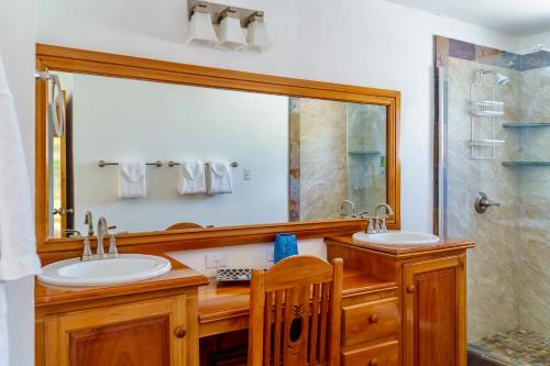 uma casa de banho com 2 lavatórios e um espelho grande em The Westender Inn em Negril