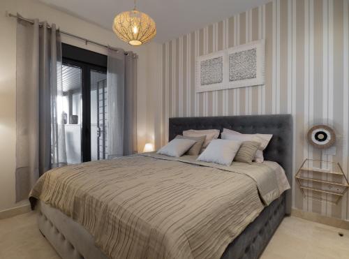 Un dormitorio con una cama grande y una lámpara de araña. en Amazing Two Bedroom Apartment in Los Flamingos, Marbella, en Estepona