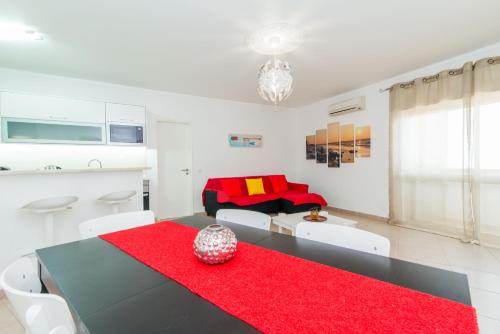 a living room with a black table and red rug at Apartamento Praia Fuzeta in Fuzeta