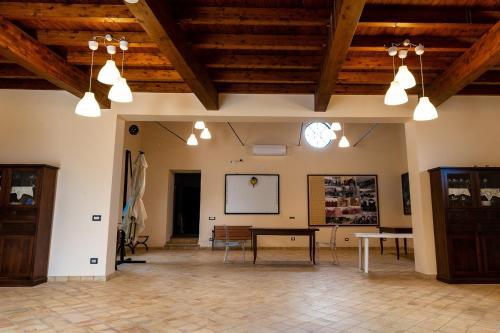 Großes Zimmer mit Holzdecken und einem Tisch in der Unterkunft Roba Albanisi in Aragona