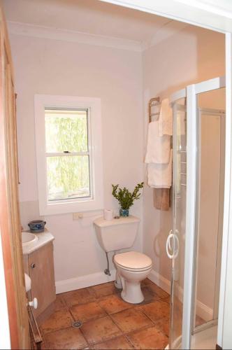 a bathroom with a toilet and a sink and a window at The Woll on Kerripit in Barrington