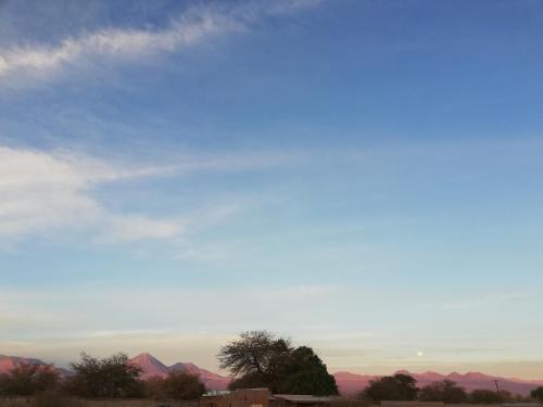 a blue sky with pink mountains in the distance at Casa Ckelar Atacama in San Pedro de Atacama