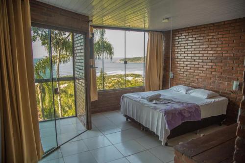 a bedroom with a bed with a view of the ocean at Pousada Estação Baleia in Praia do Rosa