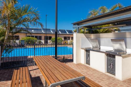 a patio with a bench and a swimming pool at Nesuto Geraldton in Geraldton