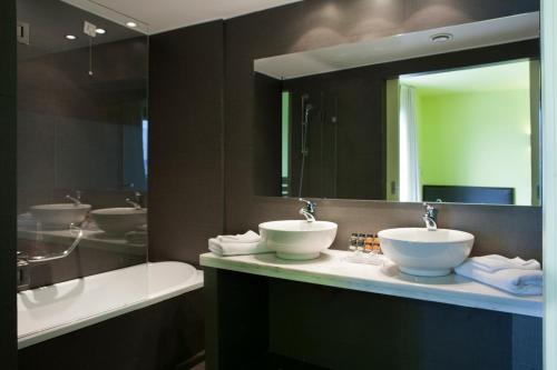 a bathroom with two sinks and a large mirror at Athens Center Square Hotel in Athens