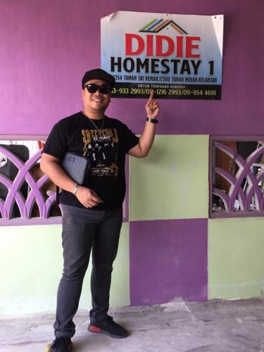 Un homme se tient devant un bâtiment dans l'établissement DIDIE HOMESTAY 1, à Tanah Merah
