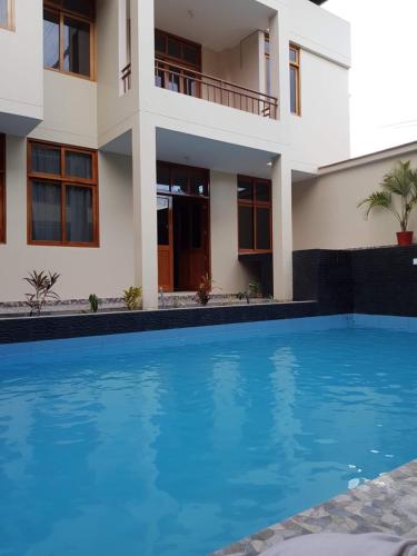 a house with a swimming pool in front of it at Hostal La Maison Canadiense in San Ramón