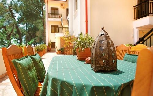 a table with a green table cloth on a table at Avra Apartments in Neos Marmaras