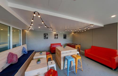a living room with a red couch and chairs at ibis budget Sydney Airport in Sydney
