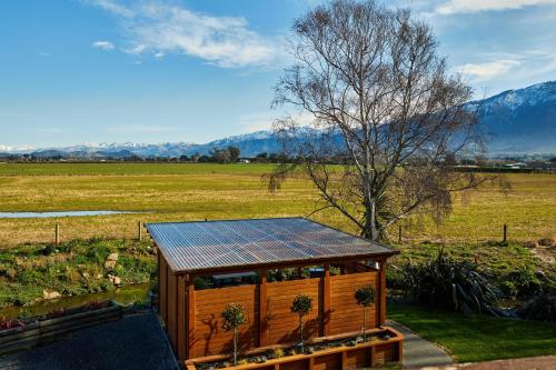 a small house with a solar roof in a field at Brook House B&B & Cottages in Kaikoura